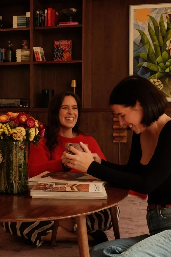 Lexi and Delana laughing together at a table with flowers