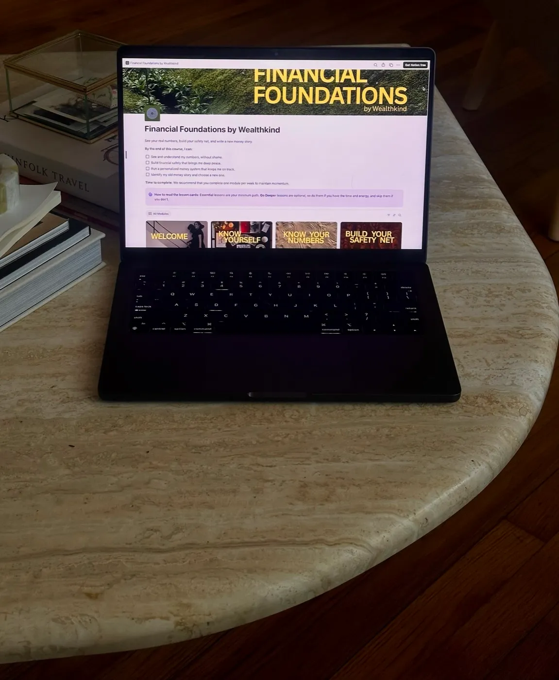Financial Foundations open on a laptop on a stone table