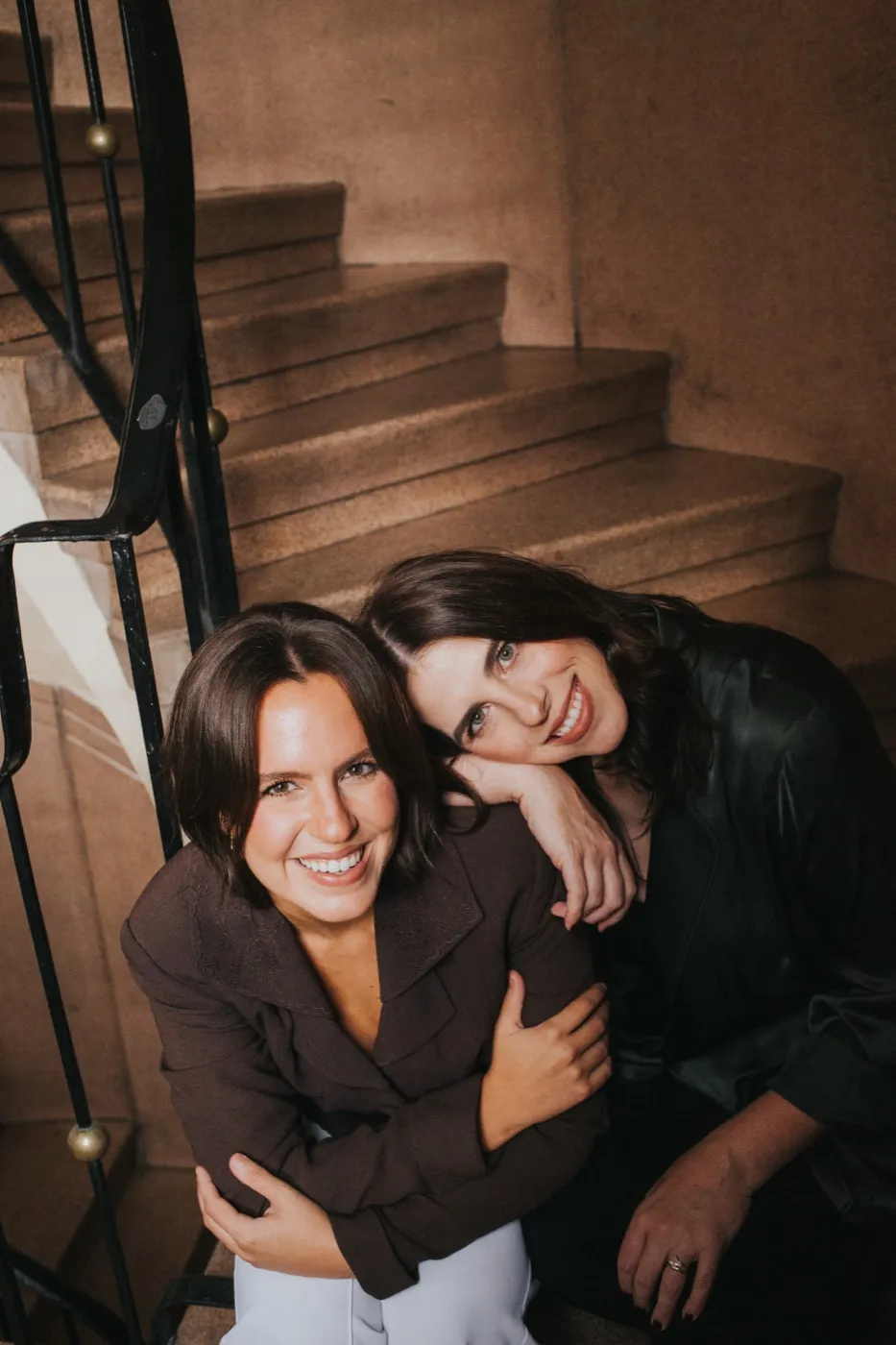 Lexi and Delana sitting together on a staircase