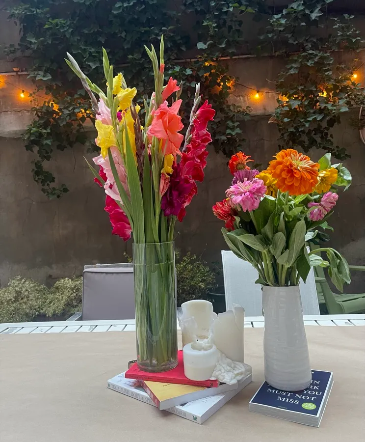 Bright flowers in vases on an outdoor table